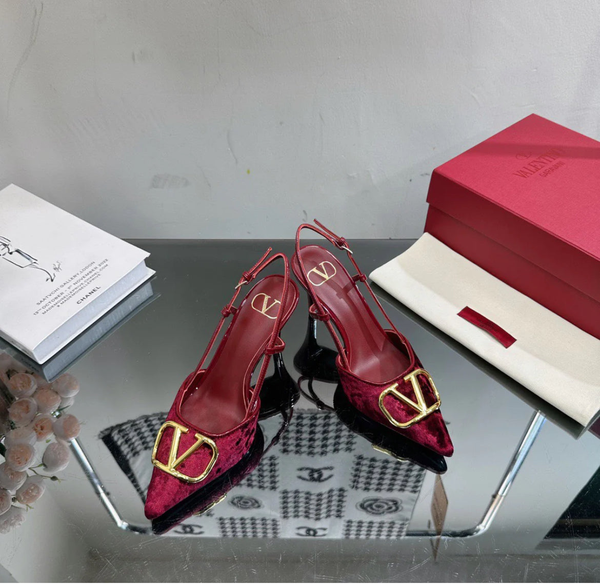 Burgundy red heels with a gold logo on the toe