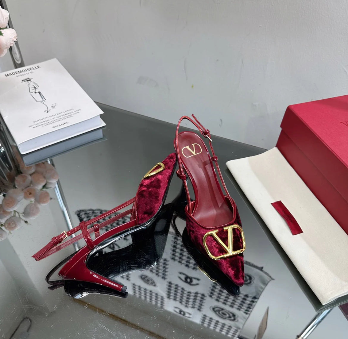 Burgundy red heels with a gold logo on the toe